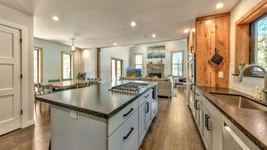 Una cocina amplia con una isla grande, armarios de madera y una chimenea de piedra.