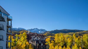 Ein Hotel im traditionellen Baustil, umgeben von Herbstlaub und einer Bergkulisse.