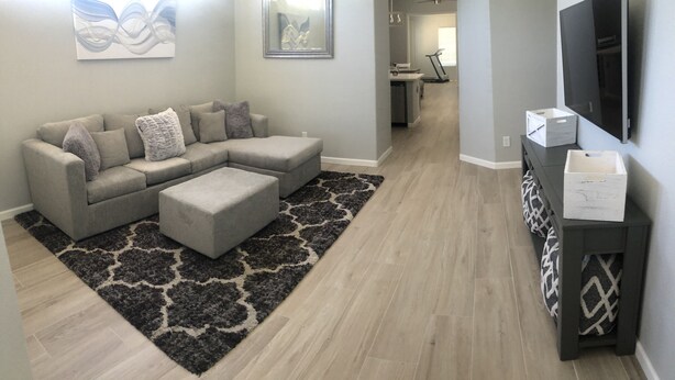 A living room with a sectional sofa, ottoman, and a black and white rug. - Beautiful, newly renovated Tucson Eastside home  (Tucson)