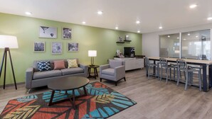 Uma sala de estar moderna com sofá, poltronas, mesa de centro e um espaço de jantar com cadeiras e mesa.