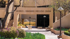 The George L. Graziadio Executive Center with a central courtyard, outdoor seating, and a staircase leading to the entrance.