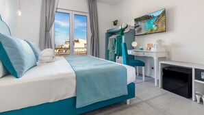 Une chambre à coucher moderne avec un lit, un bureau et un téléviseur.