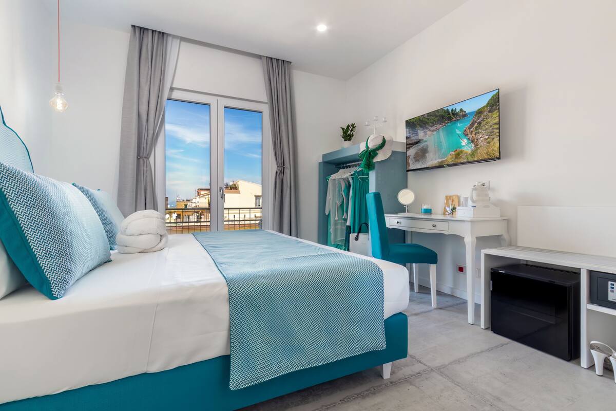 Ein modernes Schlafzimmer mit einem Bett, einem Schreibtisch und einem Fernseher.