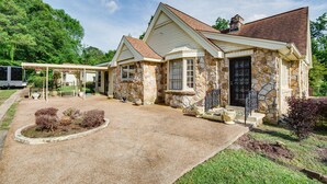 A stone house with a covered porch and a gravel driveway. - Cozy Jackson Vacation Rental < 1 Mi to University (Jackson)