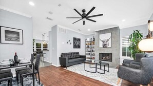 A modern living room with a grey sofa, a glass coffee table, and a fireplace.
