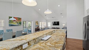 A spacious kitchen with a marble countertop, pendant lights, and a built-in refrigerator. - Anna Maria Guest House 401- 3 bedrooms in the middle of everything- 2 night mini (Anna Maria)