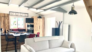 A modern kitchen with a dining area, featuring a sofa, chairs, and a table. - CAPUCINE (6 chemin des Biches, La Couarde) (La Couarde-sur-Mer)