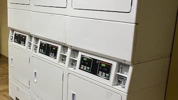A row of stacked laundry machines with control panels.