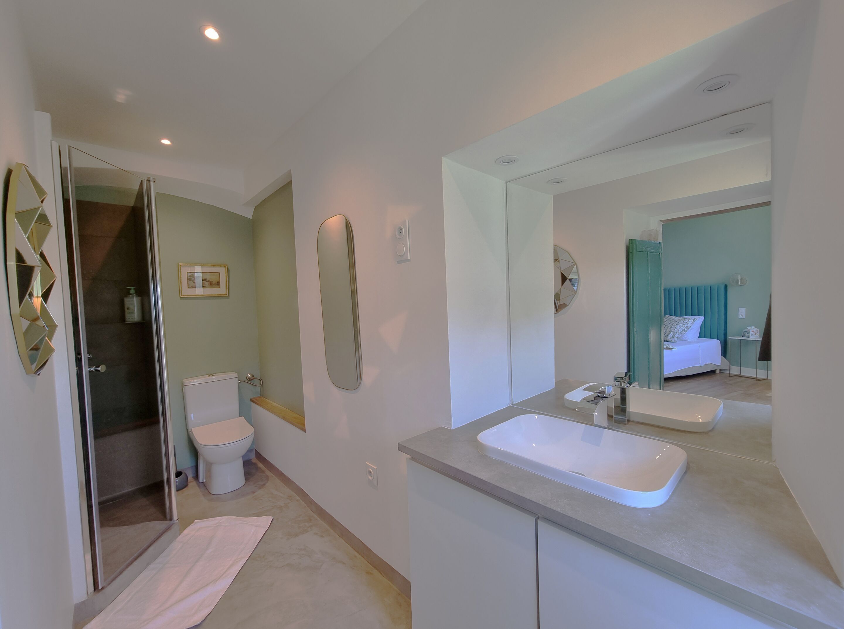 Een moderne badkamer met douche, toilet en wastafel.