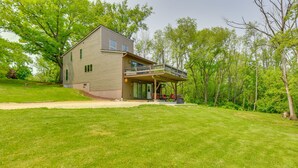 A two-story house with a covered porch and a large lawn. - Wisconsin Vacation Rental Retreat w/ Deck (Twin Lakes)
