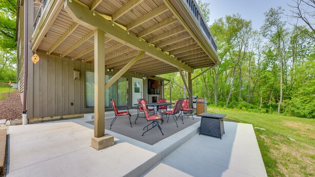 A covered patio area with outdoor furniture and a grill. - Wisconsin Vacation Rental Retreat w/ Deck (Twin Lakes)