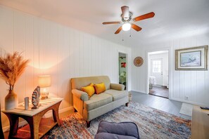 A living room with a ceiling fan, a sofa with cushions, a table with a lamp, and a rug. - Pet-Friendly Cottage Near Beach: King Bed/Fire Pit (Bonita Springs)