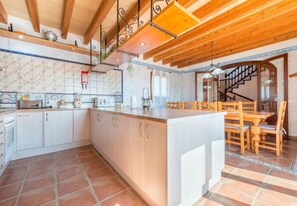 A spacious kitchen with a large island, wooden cabinets, and a tiled backsplash.