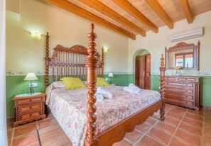 A bedroom with a four-poster bed, a wooden dresser, and a mirror above the dresser. - Country house with 5 bedrooms with barbecue and private pool (Son Carrió)