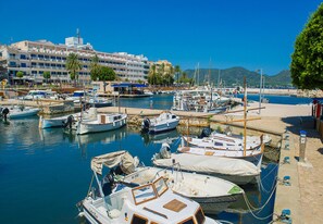 A marina with boats docked, a building with balconies, and a clear blue sky. - Country house with 5 bedrooms with barbecue and private pool (Son Carrió)