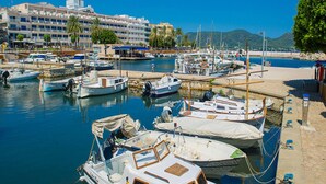 A marina with boats docked, a building with balconies, and a clear blue sky. - 3 bedroom country house with private pool and barbecue (Son Macià)
