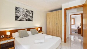 A hotel room with a large bed, wooden wardrobe, bedside tables with lamps, and a framed picture on the wall. - 3 bedroom country house with private pool and barbecue (Son Macià)
