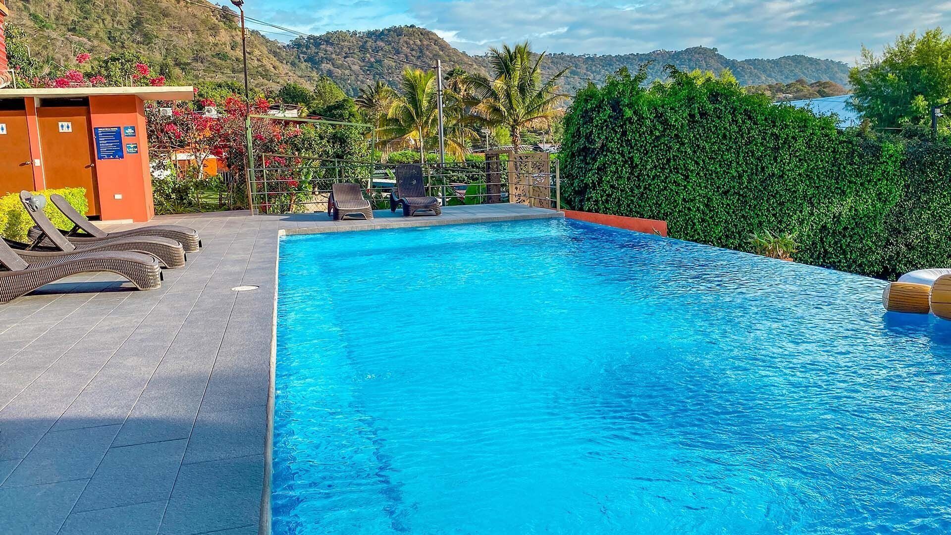 A swimming pool with lounge chairs and a small building with a sign.