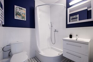 Une salle de bain moderne équipée d’une douche, de toilettes et d’un lavabo.