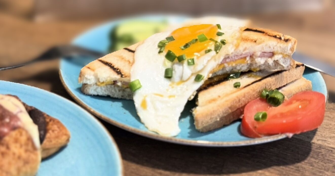 Een sandwich met een gebakken ei op een blauw bord.