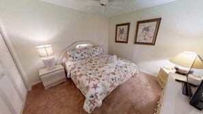 A bedroom with a bed, nightstands, a dresser, and two wall-mounted lamps.