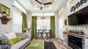 Un salon chaleureux avec un canapé, un pouf et une cheminée.