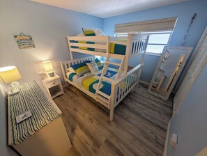 A bunk bed with a striped rug, a bedside lamp, and a wall sign. - Delightful vacation home located in the popular Islamorada neighborhood of Port Antigua. (Islamorada)