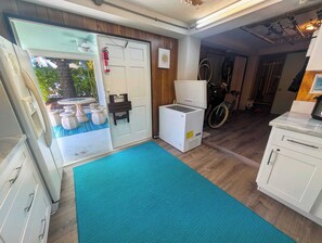 A kitchen with white cabinets, a refrigerator, a microwave, and a sink.
