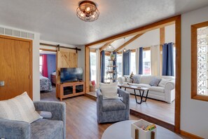 A spacious living room with a wooden ceiling, a television, a sofa, and a coffee table. - Lakefront Missouri Vacation Rental w/ Dock & Slip! (Roach)