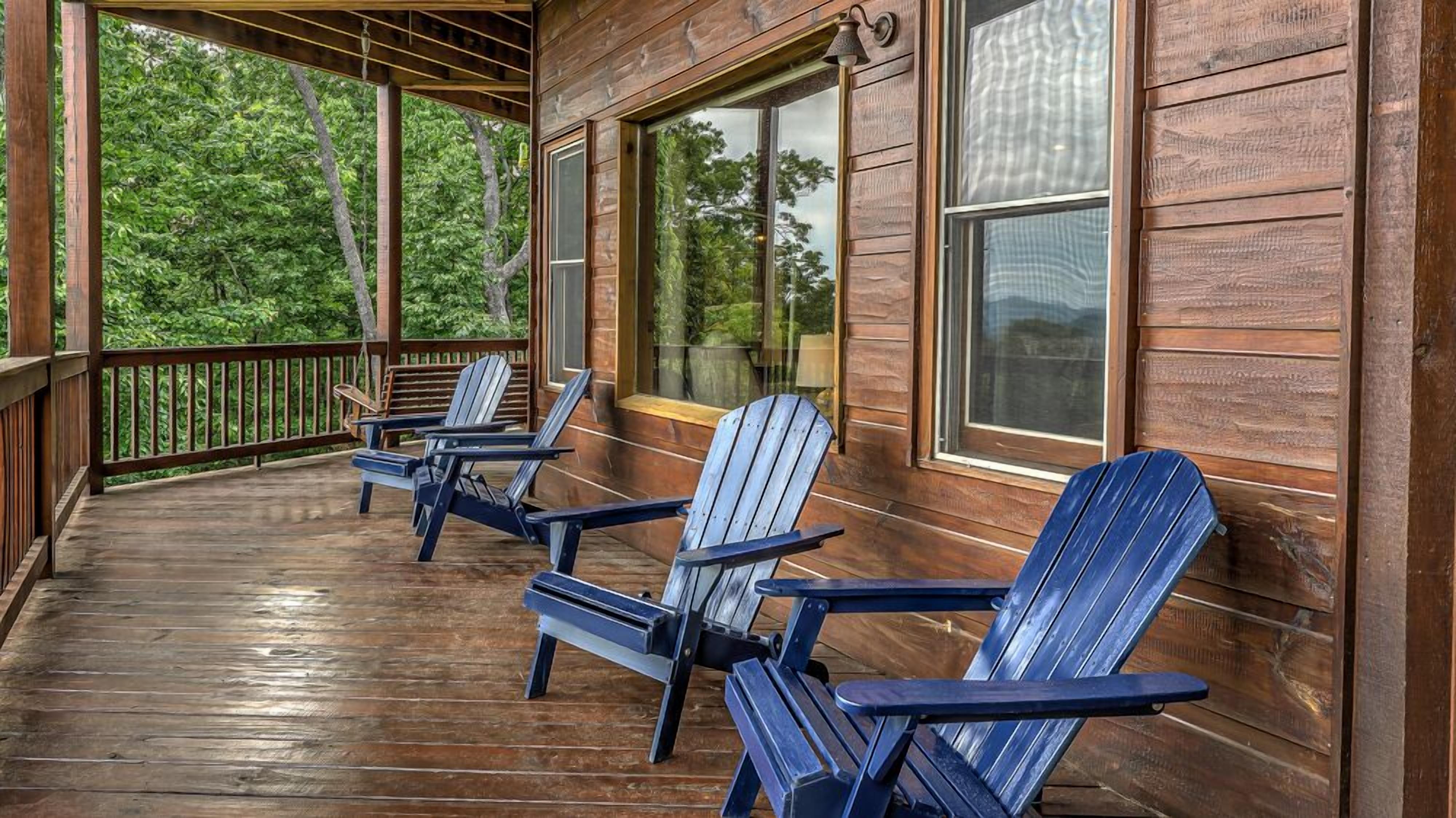 A wooden porch with Adirondack chairs and large windows.