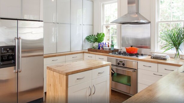 A modern kitchen with white cabinets, stainless steel appliances, a wooden countertop, and a large window providing natural light. - 5 Queen Beds, Downtown, Park in Private Driveway, Stroll to Charleston's Best (Charleston)