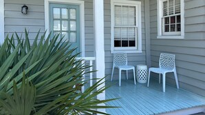 A porch with a light blue wooden floor, white railings, and three white chairs. - 5 Queen Beds, Downtown, Park in Private Driveway, Stroll to Charleston's Best (Charleston)