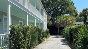A gravel pathway leading to a building with a white porch and multiple windows. - 5 Queen Beds, Downtown, Park in Private Driveway, Stroll to Charleston's Best (Charleston)