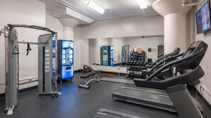 Una palestra con tapis roulant, macchinari per pesi e un display Cybex.