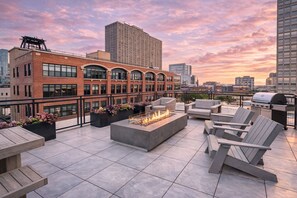 A rooftop terrace with outdoor seating, a fire pit, and a view of the city skyline. - McCormick Oasis with Balcony, Patio and Gym Near Soldier Field & Museum Campus (Chicago)