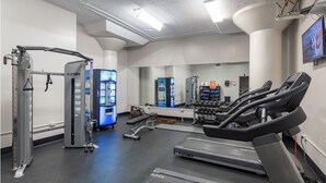 A gym with treadmills, weight machines, and a water dispenser.