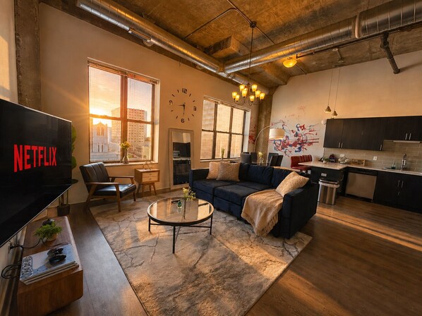 A modern living room with a sofa, coffee table, and a TV displaying the Netflix logo.