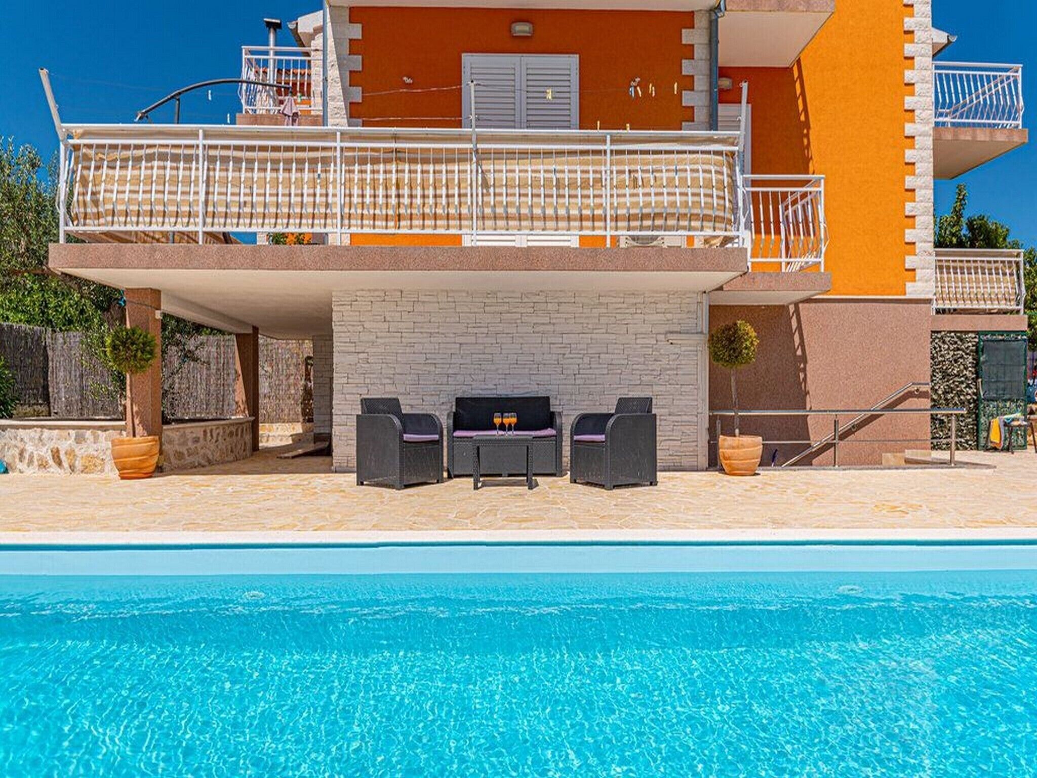Ein Poolbereich mit Grillmöglichkeit und Gartenmöbeln.