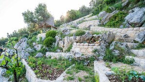 Eine steinerne Stützmauer mit einem Garten.