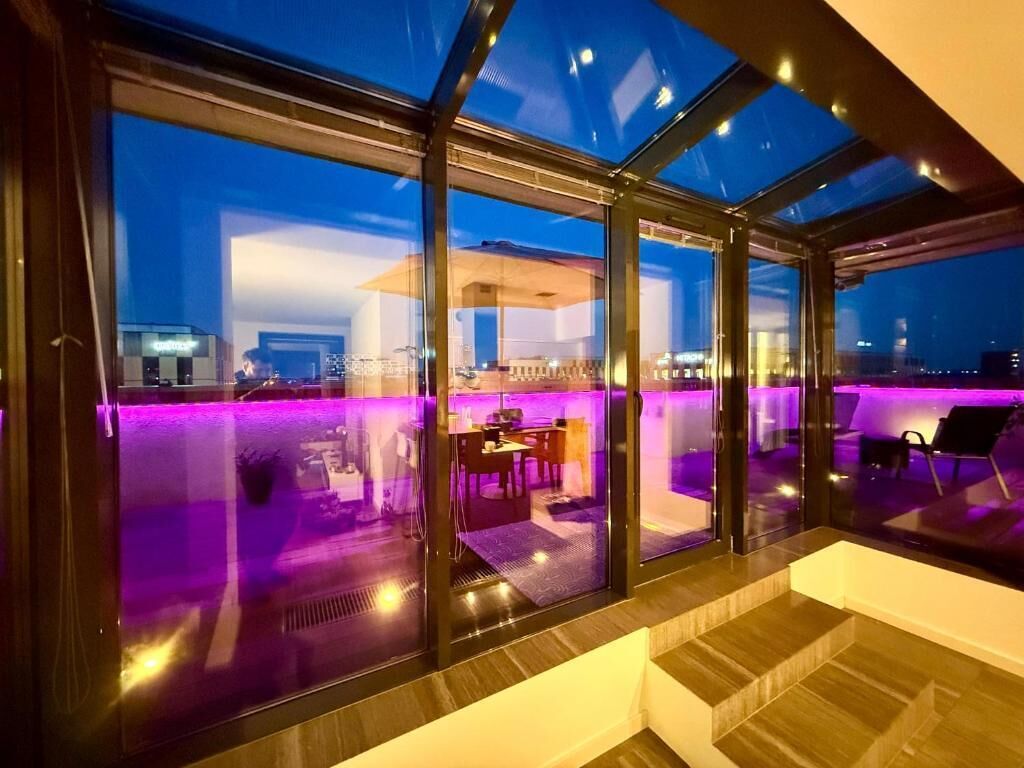 Un interior moderno con amplios ventanales, un comedor y vistas a la ciudad.