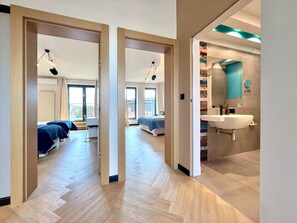 A hotel room with a large bed, a desk, and a view of the city. - Angel Mint Apartment (Kraków)