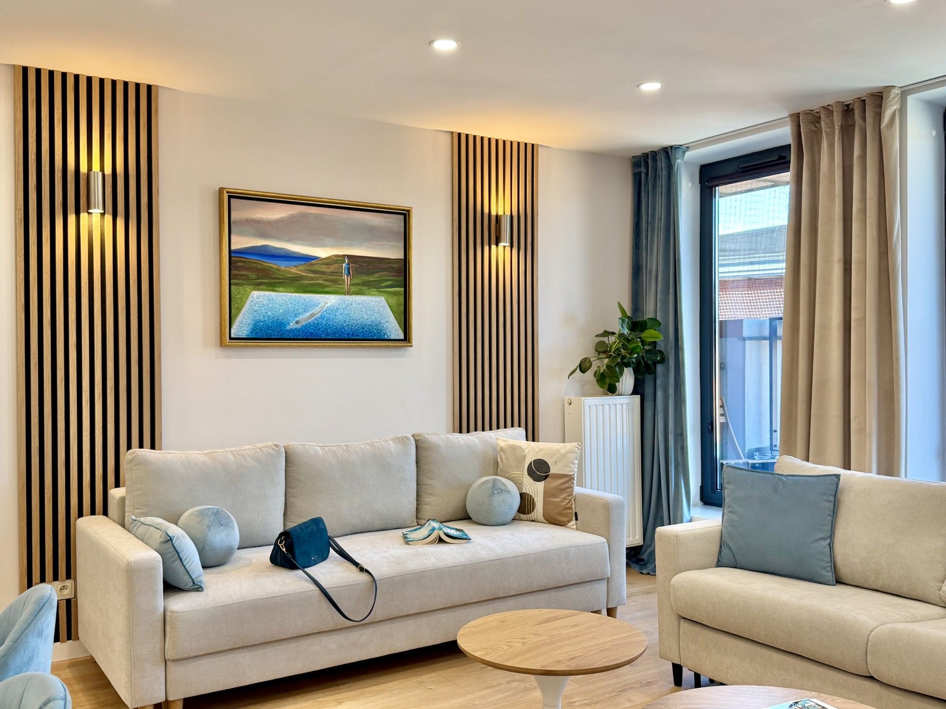 A modern living room with a sofa, a coffee table, and a painting on the wall.