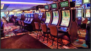 A row of slot machines in a casino with a carpeted floor and a ceiling with recessed lighting. - Stockade Japanese Ryokan, King bed, Washer/Dryer (Schenectady)