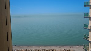Vista di un mare calmo da un balcone, cielo sereno.