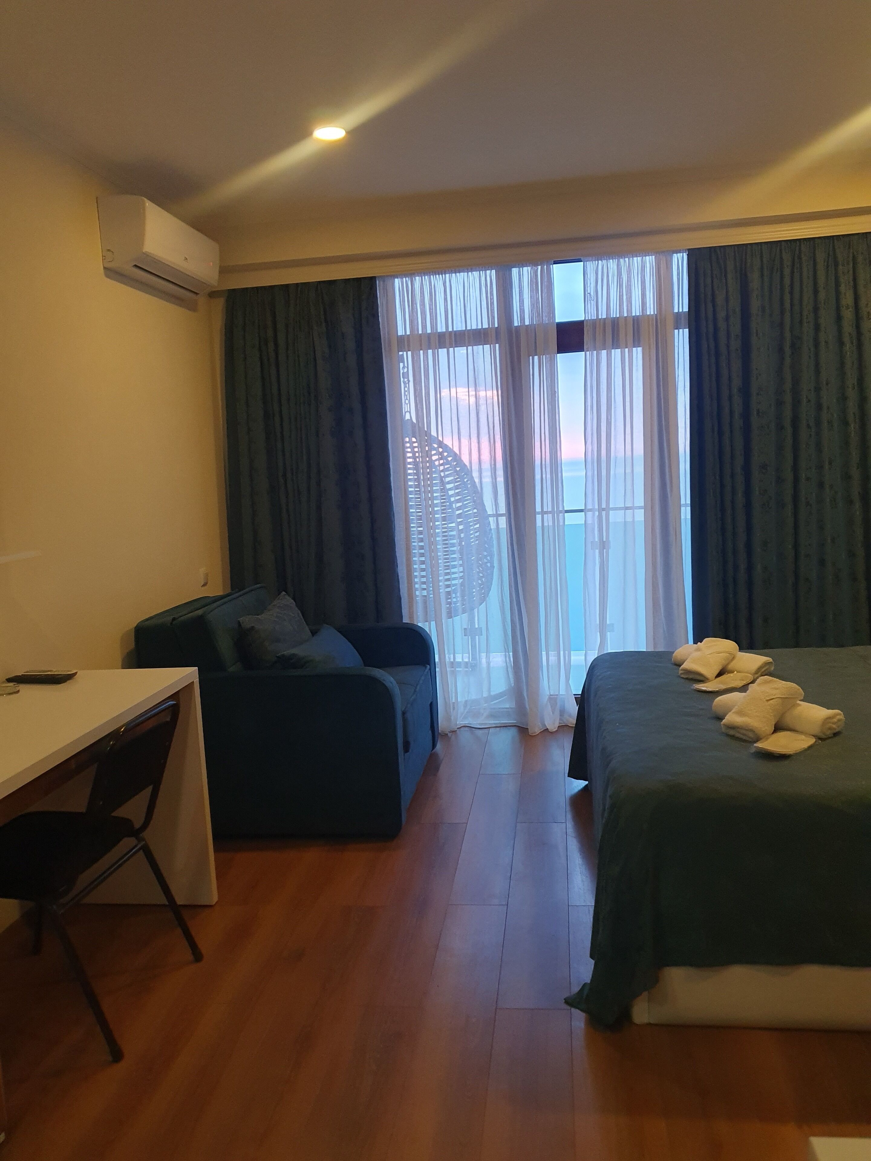 Une chambre d’hôtel avec un lit, un bureau, une chaise et un canapé.