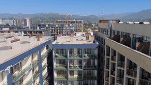 A multi-story building with balconies, large windows, and a construction site in the background. - Fresh Wave Hotel (Batumi)
