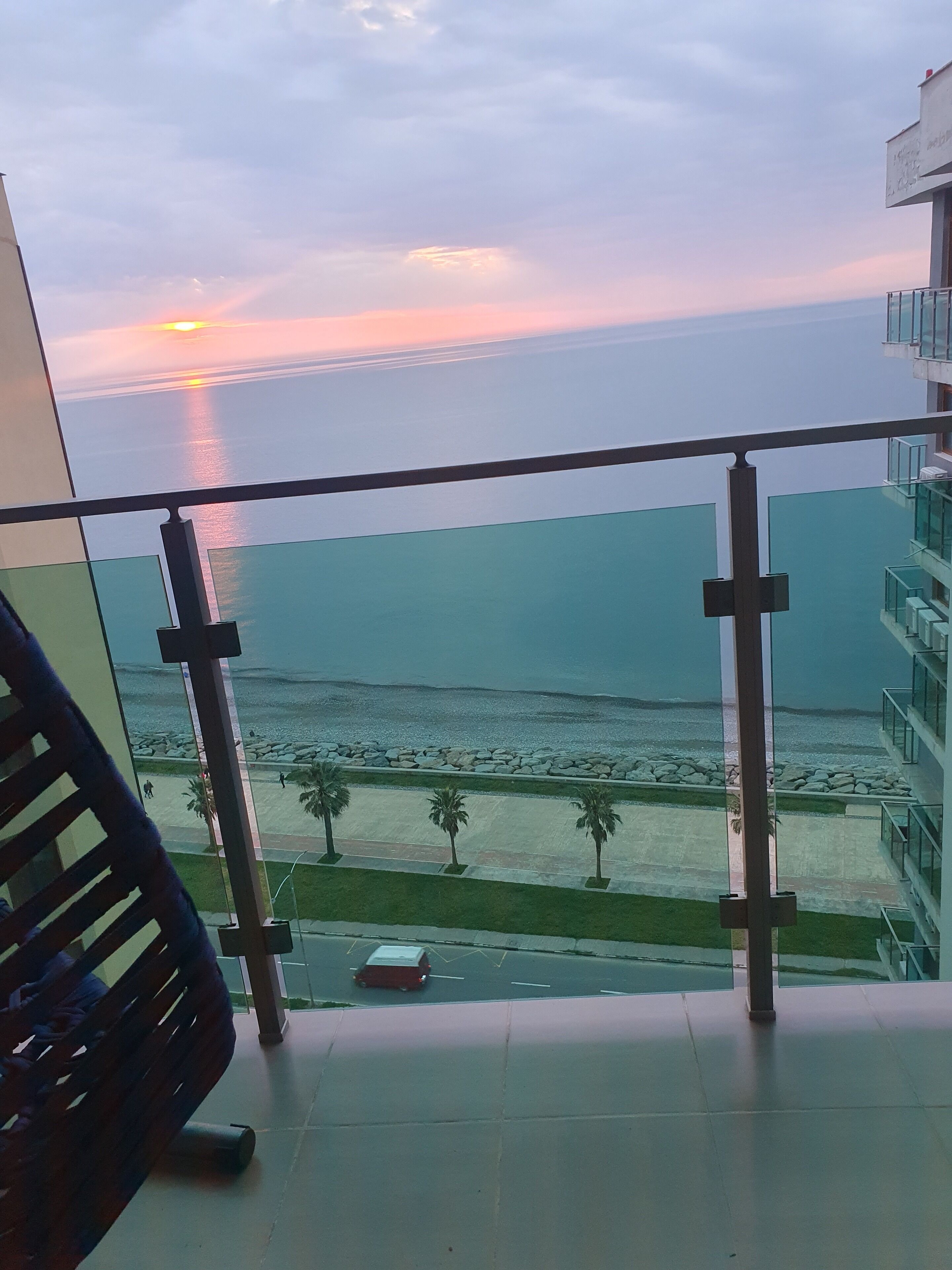 Ein Balkon mit Blick auf das Meer bei Sonnenuntergang.