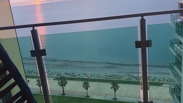 Ein Balkon mit Blick auf das Meer bei Sonnenuntergang.