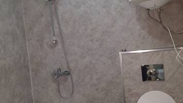 Un baño con bañera, inodoro y ducha.