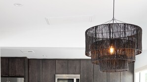 Une cuisine moderne avec des meubles de couleur sombre, des appareils en acier inoxydable et un îlot central doté de sièges.